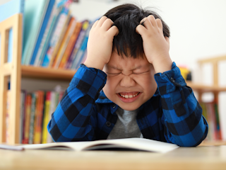 Young boy struggling with reading